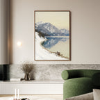 A living room features a green curved sofa and the Winter Reflection Canvas Art - Vertical, showcasing a snowy mountain mirrored in a calm lake above a marble ledge with dried branches, evoking serene Nordic Park vibes.