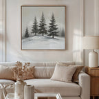 A cozy living room features a beige sofa, neutral pillows, a dried floral arrangement on the coffee table, and "Winter Solitude Canvas Art - Square" depicting snowy pines above the couch. A lamp rests on a wooden side table.